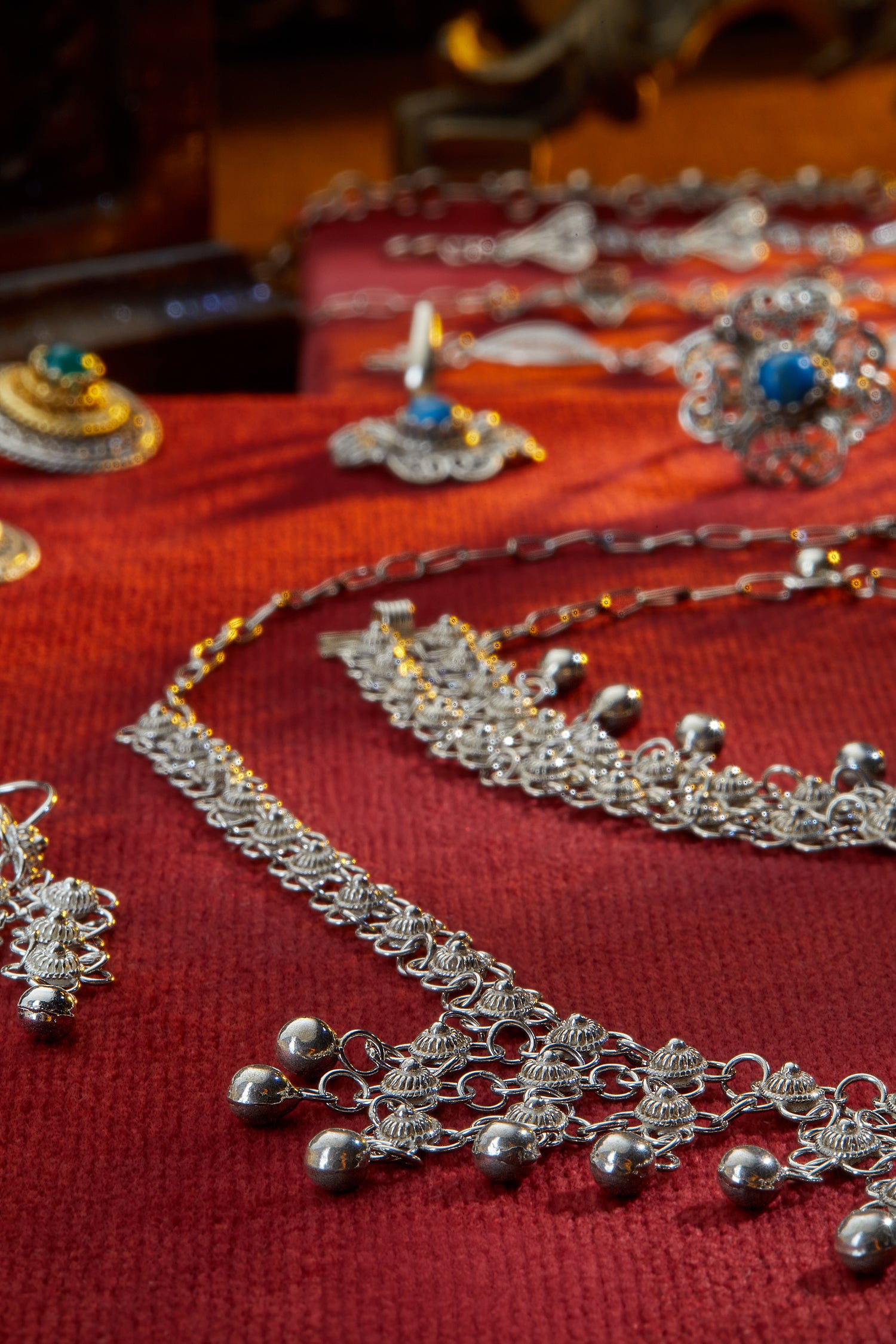 Silver jewelry set on a red fabric background
